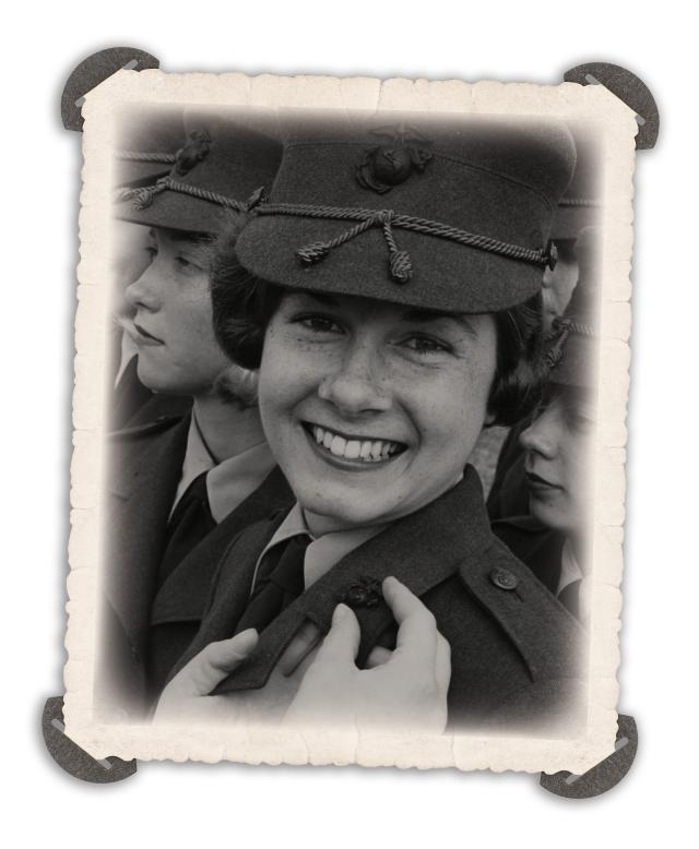 Private Diane Curtis smiles as she receives her Marine Corps emblems during March 1967 graduation exercises at Marine Corps Recruit Depot, Parris Island, South Carolina. The emblem-pinning ceremony signifies the recruit has successfully completed recruit training.