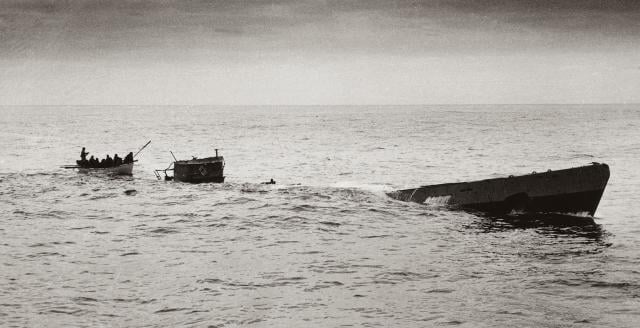Having blasted U-175 to the surface, Coast Guardsmen from the Spencer approach by boat, making ready to board the conning tower and rescue survivors before the U-boat sinks in the waters southwest of Ireland.