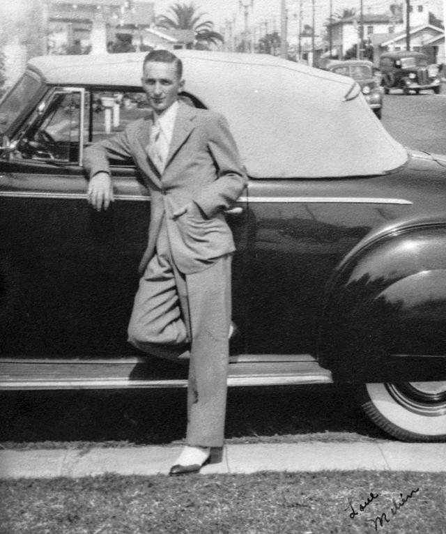 Melvin Murdock posing on an automobile