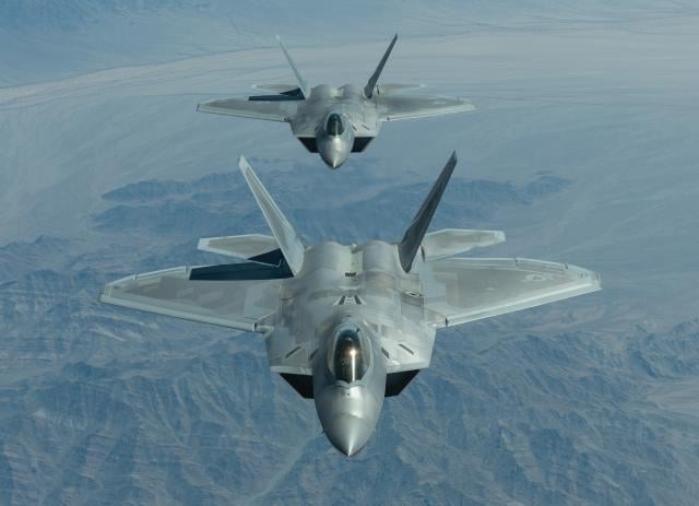 An integrated strike mission might include Air Force F-22 Raptors (above) conducting Rapid Raptor operations from an austere airfield, providing an offensive counterair screen for a destructive SEAD element of four Marine Corps F-35Bs being dragged 1,000 nm from their “forward” operating base by two KC-130s.