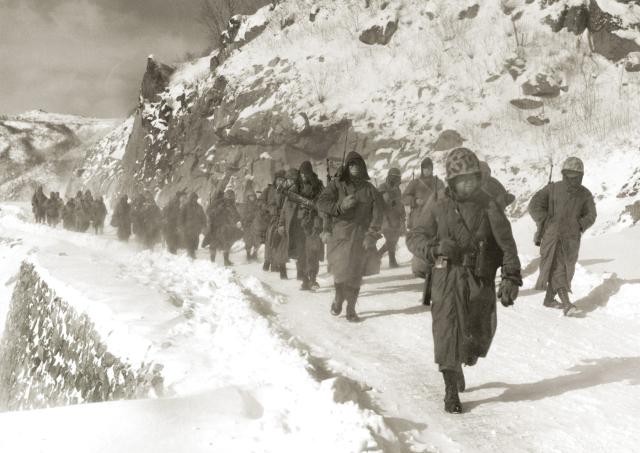 9 December 1950: Marines of the 1st Marine Division march through mountain terrain in subzero weather during the Korean War’s Battle of Chosin Reservoir—one of the deadliest of the war.