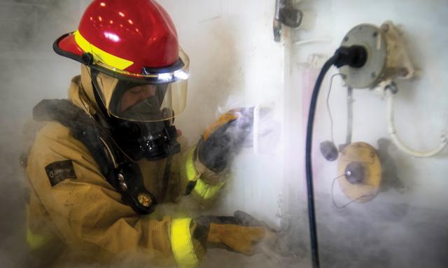 A damage controlman prepares to fight a simulated fire in the hangar bay of the USS George H. W. Bush (CVN-77). Most sailors will experience combat through damage control. Not coincidentally, this mission comes with perhaps the best doctrine—and certainly the most developed training methods. 