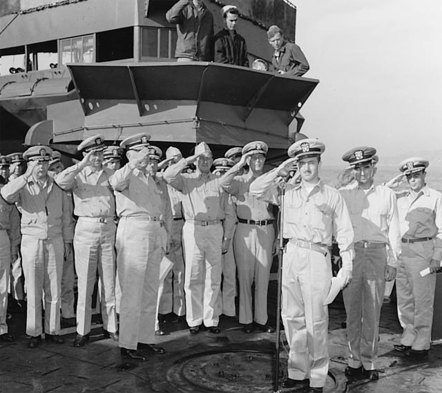Back in the fold at last: Officers salute as the National Anthem is played during recommissioning ceremonies on the ex-Stewart’s foredeck while moored in Hiro Wan, Japan, 29 October 1945.