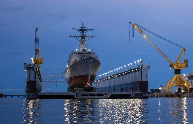 The guided-missile destroyer USS Jack H. Lucas (DDG-125) seen in June 2021 preparing for her commissioning in Pascagoula, Mississippi. In 2002, the HII Pascagoula yard was owned by Northrop Grumman Ship Systems, which grudgingly agreed to a Navy proposal to send some DDG construction to Bath Iron Works in Maine in return for taking on construction of the full San Antonio–class amphibious transport dock line instead of sharing production with Bath.