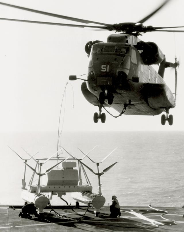 A CH-53A Sea Stallion from Combat Support Squadron 6 on board the amphibious ship Raleigh (LPD-1) about to lift a Mk 105 hydrofoil minesweeping sled in 1971.