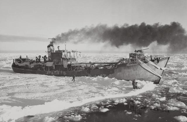 The Externsteine is pictured on the verge of being freed from the captive ice, which aided in her capture. Note her mottled camouflage and the white “bunting” spread over her bow and superstructure to aid in disguise against the icy background.
