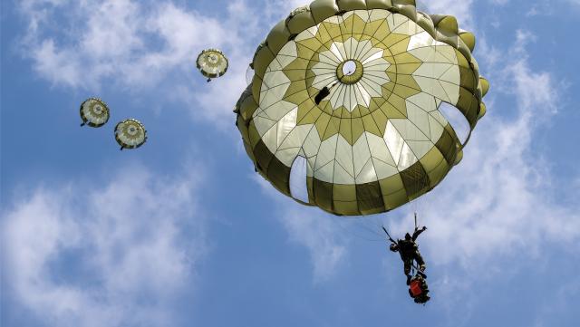 Japan Ground Self-Defense Force soldiers from the 1st Airborne Brigade descend from a U.S. Air Force C-130J Super Hercules over Narashino Training Area, Japan, in April 2022.
