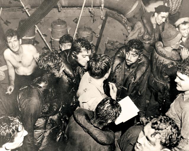 Oily survivors from the torpedoed USS Helena are taken aboard the USS Nicholas (DD-449) after the July 1943 Battle of Kula Gulf. 