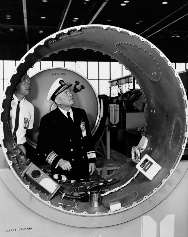 Rear Admiral William F. Raborn Jr. examining a Polaris test vehicle component.