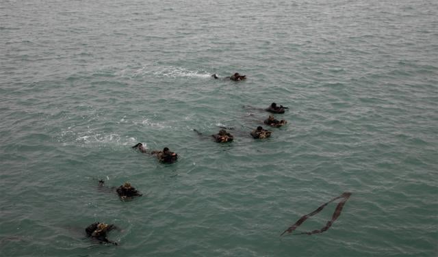 U.S. Navy SEALs swim onto the beach and begin tactical movements during Operation Polar Dagger at Eareckson Air Station on Shemya Island.