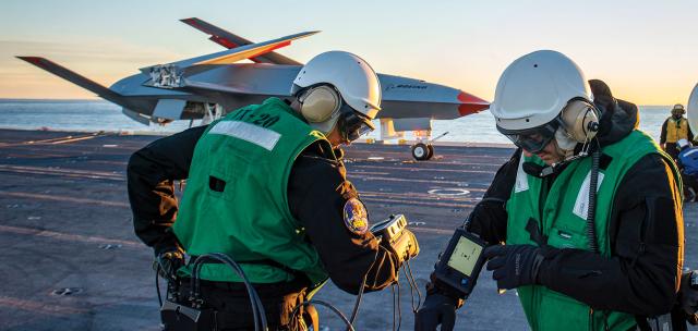 Boeing unmanned MQ-25 aircraft is given operating directions on the USS George H. W. Bush (CVN-77) flight deck