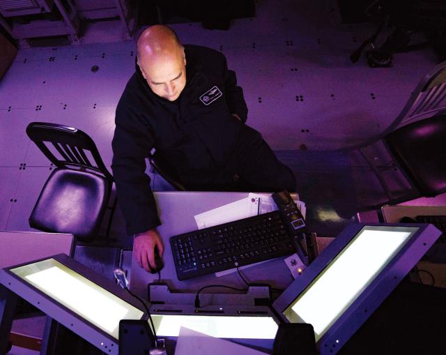 An intelligence specialist monitors an indications-and-warning console on board the amphibious transport dock USS Arlington (LPD-24). Greater Navy involvement in homeland defense missions likely will fall more heavily on the amphibious fleet.
