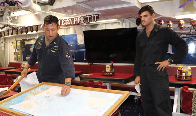 On board the USS Paul Hamilton (DDG-60), a division officer and chief use maps and ship models to illustrate the Battle of Midway and its application to current warfare.