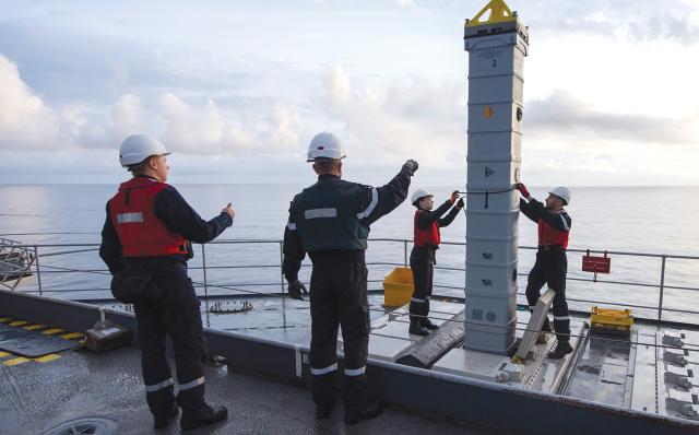 A vertical launching system cell with an Aster missile is loaded on to the French nuclear-powered aircraft carrier Charles de Gaulle while underway. If shore support is not an option during conflict, technical solutions must be developed for complex ammunition replenishment at sea. 