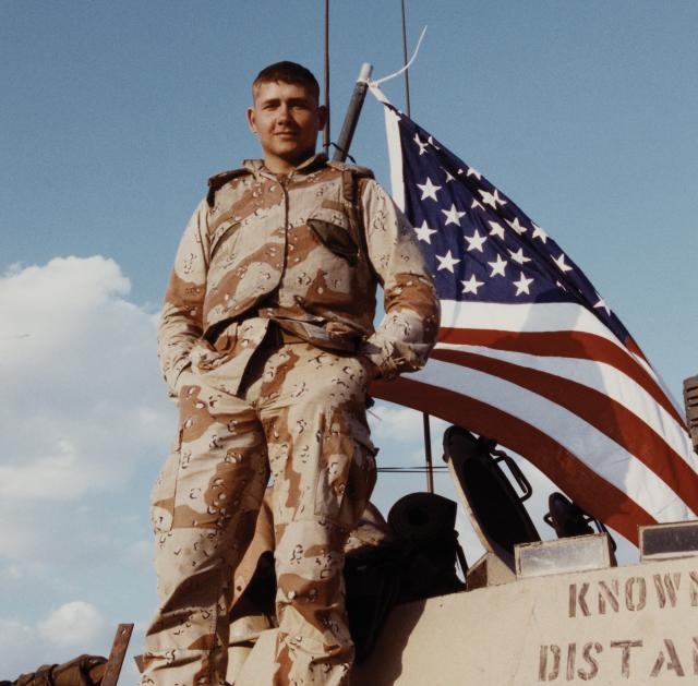 A lightning strike, a resounding victory: A U.S. Marine savors the moment atop a military vehicle during celebrations after the liberation of Kuwait.