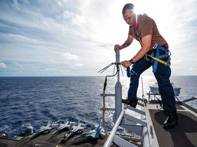 Navy information systems technician conducts antenna maintenance 