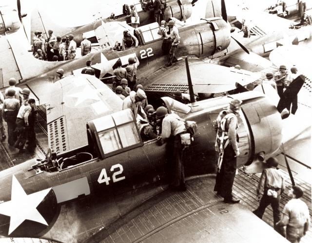 Pilots and gunners of Bombing Squadron 16 (VB-16) climb out of their Douglas SBD-5 bombers onto the flight deck of the USS Lexington after returning from the Tarawa-Makin raid, 18 September 1943.