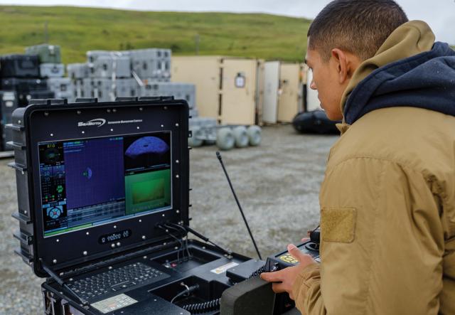 Sailor controls remotely operated vehicle to identify underwater objects.