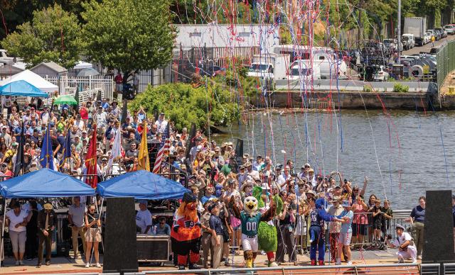 A crowd-filled waterfront, colorful confetti, and great fanfare greet the historic battleship on her arrival.