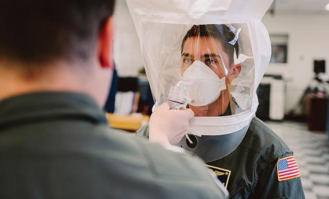 A Coast Guard aviation survival technician is fitted for an N95 respirator at Air Station Kodiak, Alaska.