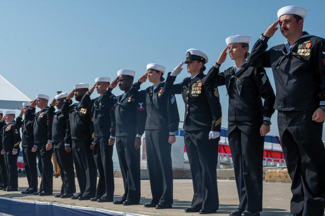 At Naval Weapons Station Earle, New Jersey, sailors assigned to the USS New Jersey (SSN-796) salute the audience during the submarine’s commissioning ceremony on 14 September  2024. The New Jersey is the fifth Block IV Virginia-class submarine and the first in its class designed and built with modifications for a gender-integrated crew. 