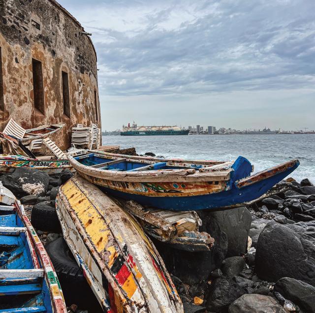 	View of Dakar LT Jacob Crnkovich, USN Traditional pirogues (foreground) have been used  by Senegalese fishermen for hundreds of years; the Karmol power ship in the background arrived recently and provides electrical power to Dakar.  Île de Gorée, Senegal, August 2023.