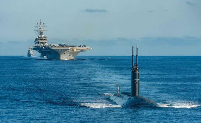 The USS Ronald Reagan (CVN-76), a Los Angeles–class fast-attack submarine, and Japan Maritime Self-Defense Force destroyer Asahi steam in formation in waters east of the Korean Peninsula.