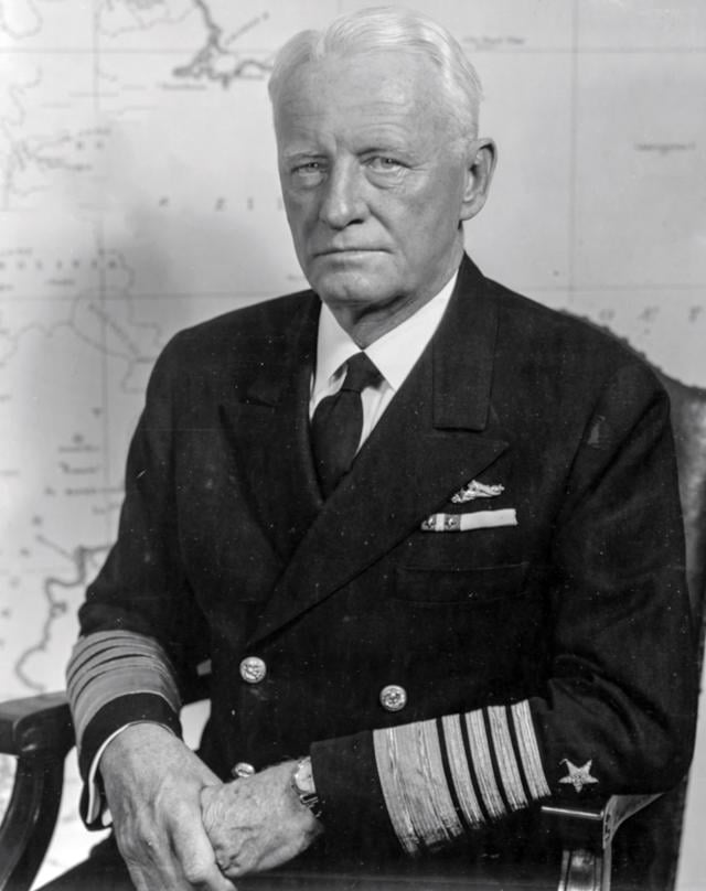 Portrait of Admiral Chester W. Nimiz seated in front of a map