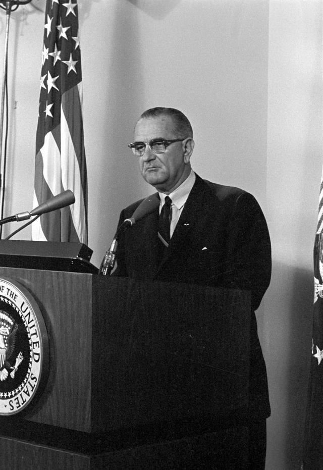 President Lyndon Johnson standing at a lectern.
