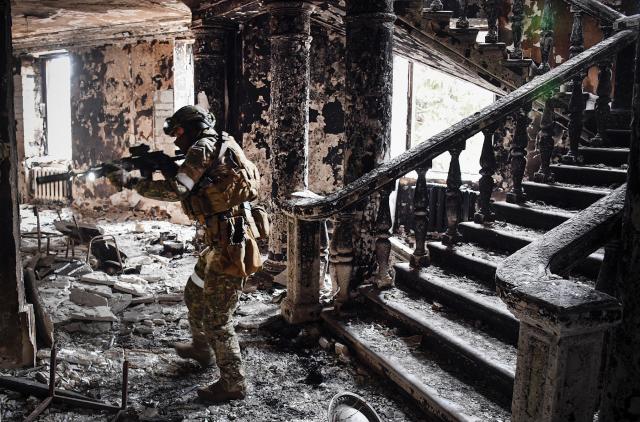 A Russian soldier patrols at the Mariupol Drama Theatre in April 2022 in Mariupol, Ukraine. Relying on speed and confusion, Russia planned to use cyber to overwhelm the Ukrainian population with disinformation while disabling internal communications. Russia has instead had to wage a war of attrition because cyber forces were unable to generate the chaos and destruction most analysts anticipated.