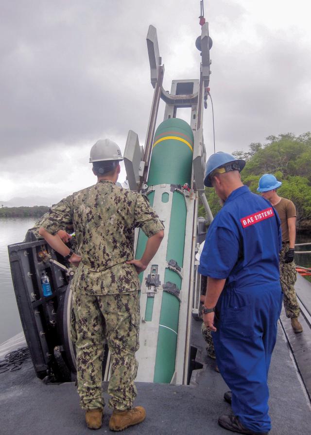 Sailors load a Harpoon anti-ship cruise missile aboard the Los Angeles-class fast-attack submarine USS Olympia (SSN-717) 
