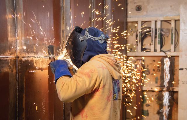 A Newport News Shipbuilding worker grinds on a camera foundation on board the aircraft carrier USS John C. Stennis (CVN-74). The new administration should consider expanding public naval shipyards and establishing new commercial yards to increase the pace of shipbuilding and keep up with maintenance and repairs on ships currently in the fleet.