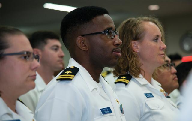 Surface Warfare Schools Command (SWSC) department head students at their graduation. Currently, SWSC disseminates curriculum to various schoolhouses, but consolidating SWO training at one location would allow direct oversight and improve the speed and standardization for changes to curricula.
