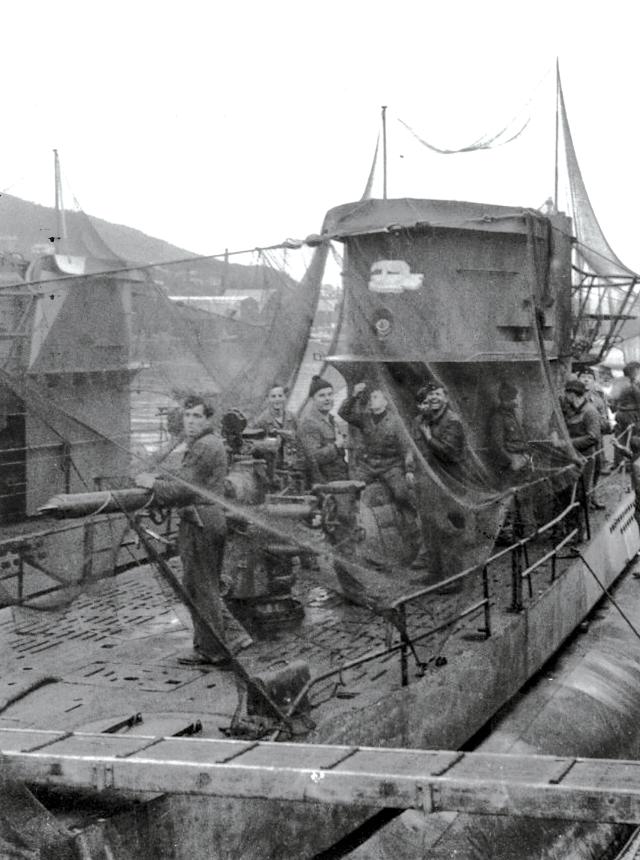 Submariners of U-405 leaning against the boat’s 88-mm deck gun.