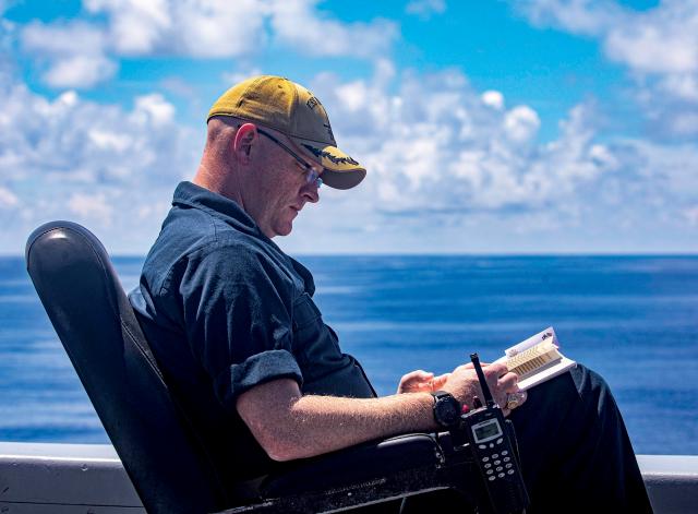 The executive officer of the USS New York (LPD-21) enjoys some reading time while under way this past July in the Sixth Fleet area of operations. Science has recently shown that reading more challenging literary fiction enhances a variety of leadership skills.