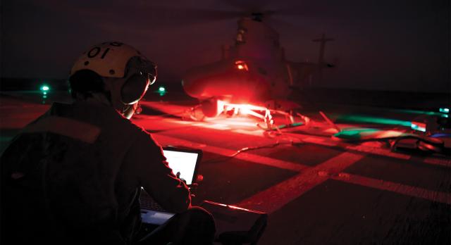 An aviation machinist’s mate performs preflight maintenance on an MQ-8B Fire Scout. As the services continue to field unmanned platforms that rely on artificial intelligence, the focus should be on capabilities and maintaining a balance of human and machine responsibilities as systems and threats evolve. 