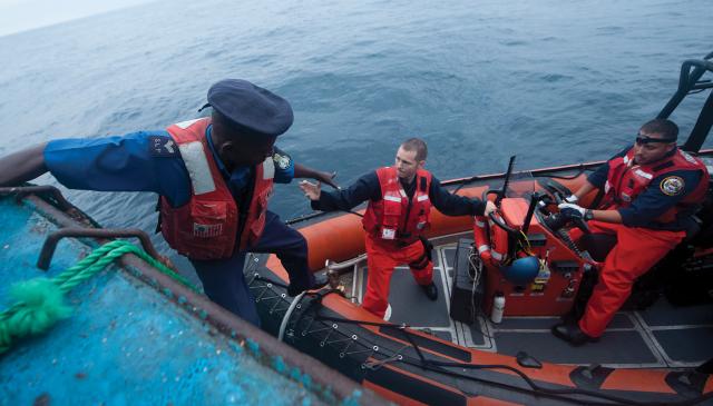 U.S. Coast Guard and Sierra Leone Police Marine Department personnel conduct a fishing boat boarding during a joint operation. The African Maritime Law Enforcement Partnership between the United States and several African countries could serve as a model for the U.S. contribution to the multinational fisheries patrol in the South China Sea.