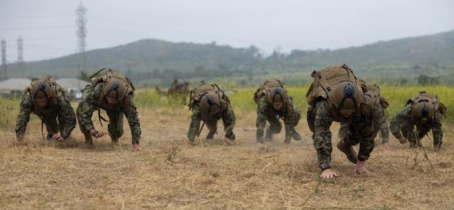Marine Corps and Navy Reserve officers bear crawl during a tactical combat casualty-care training exercise as part of officer training. Reserve enlisted sailors and junior officers are not expected to cover nonlocal travel expenses, nor are active-duty personnel—only senior officers in the Reserve.