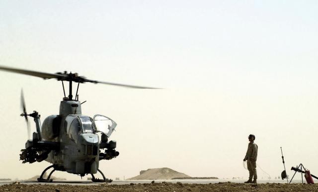 A Marine from Marine Wing Support Squadron 371 waits to fuel an AH-1W Super Cobra at a forward arming and refueling point at Tallil Air Base, Iraq, during Operation Iraqi Freedom. Mobile FARP crews like those employed in Iraq could be deployed quickly to sites containing prepositioned equipment and supplies, reducing their chances of being targeted by adversary fires.