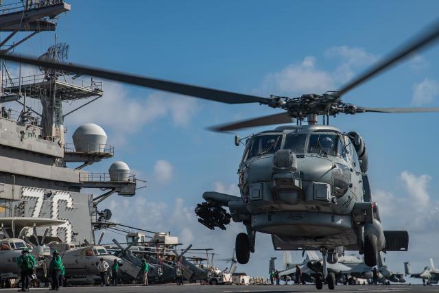 An MH-60R from HSM-77 lifts off from the flight deck of the aircraft carrier USS Ronald Reagan (CVN-76). Naval aviation is looking at all aspects of the carrier air wing, including what roles helicopters should play in great power conflict in the Pacific.