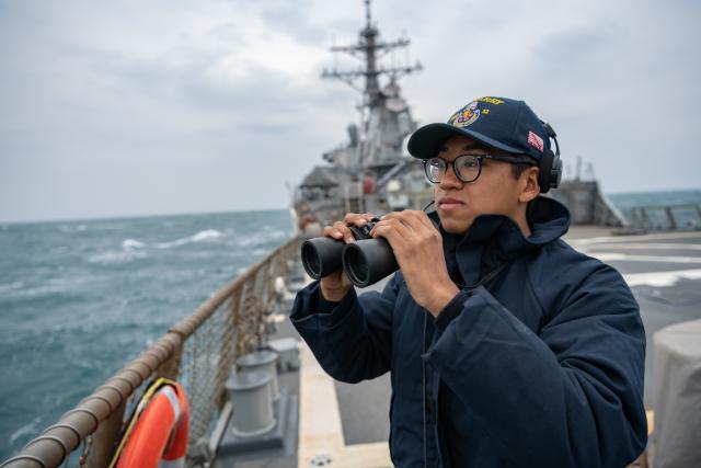 A lookout stands watch on board the USS Barry (DDG-52) during a recent transit of the Taiwan Strait.