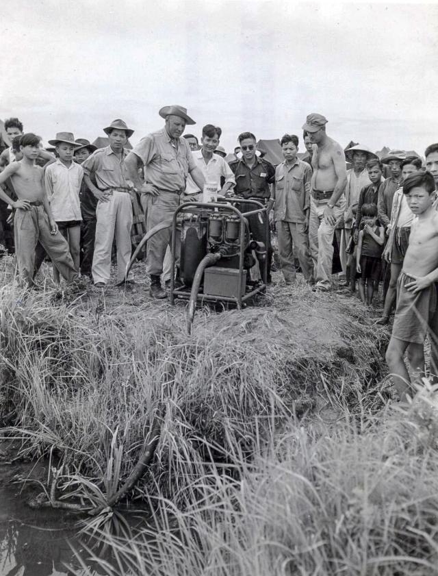 Dr. Amberson demonstrating a water purification unit to Vietnamese villagers
