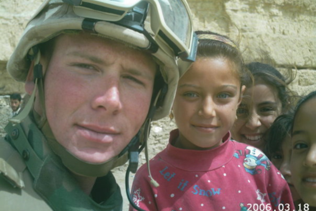 A U.S. Marine with an Iraqi girl in Al Anbar in 2005