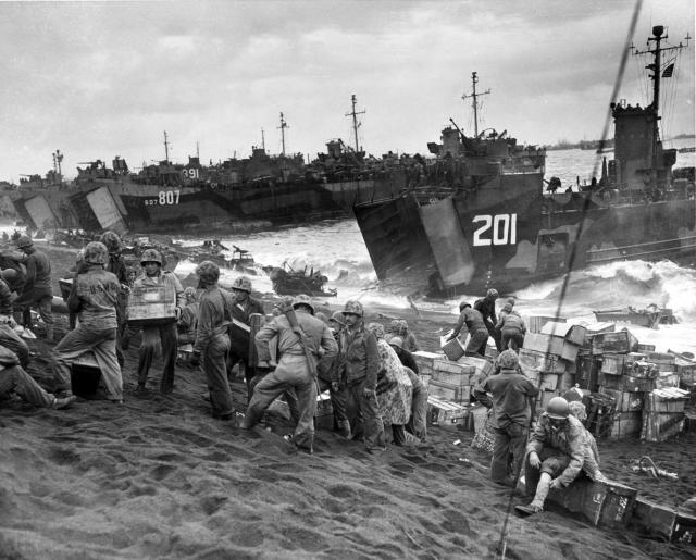 Marines unload supplies from LSM-201 and LST-807 on Iwo Jima's beach.