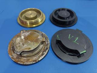 Shipboard metal external deck valve covers that have corrosion issues next to their 3-D–printed parts in development for fabrication.