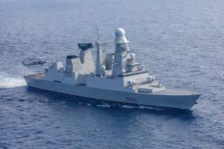 A U.S. MH-60S Knighthawk helicopter hovers over the Italian Navy Orizzonte-class destroyer Caio Duilio