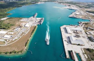 Naval Base Guam, with several Navy vessels moored in the harbor. In preparation for a possible war with China over Taiwan, the United States should prioritize improving air and missile defenses in the second island chain, as China’s ground-launched ballistic missiles could be as effective as Japan’s land-based bombers were during World War II.