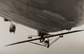 A glider is secured to the underside of the USS Los Angeles (ZR-3)