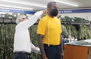 sailor gets fitted for the khaki uniform at Navy Exchange 