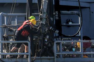 Merchant mariners on board the dry-cargo ship USNS Carl Brashear (T-AKE-7) prepare to release a  fuel probe to the USS Shoup (DDG-86) in the Philippine Sea. Like the military, the Merchant Marine struggles with recruiting, and financial incentives alone might not provide sufficient crews for ships that sail into harm’s way. 